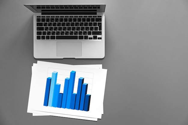 Grafici e laptop stampati su superficie grigio scuro