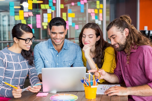 Grafici sorridenti che discutono sopra il computer portatile nella riunione