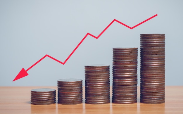 Grafico a freccia rossa del concetto di inflazione con righe di monete in concetto per la FED considerando gli aumenti dei tassi di interesse economia globale e controllo dell'inflazione