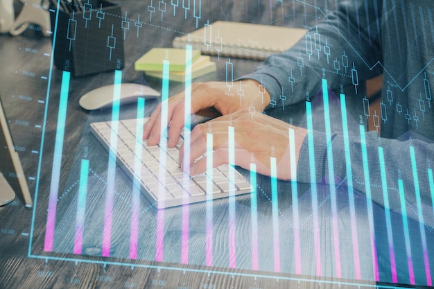 Grafico azionario con uomo d'affari che digita sul computer in ufficio sullo sfondo Concetto di analisi Doppia esposizione