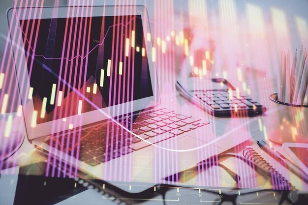 Grafico del mercato azionario sullo sfondo con scrivania e personal computer Esposizione multipla Concetto di analisi finanziaria