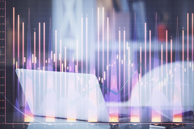 Grafico del mercato azionario sullo sfondo con scrivania e personal computer Esposizione multipla Concetto di analisi finanziaria