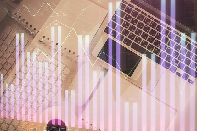 Grafico del mercato finanziario e computer con vista dall'alto sullo sfondo del desktop Concetto di investimento a esposizione multipla