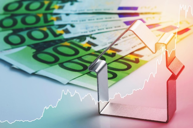 Grafico della casa in metallo e della linea scintillante in aumento che rappresenta il prezzo immobiliare o il tasso di riferimento in Europa