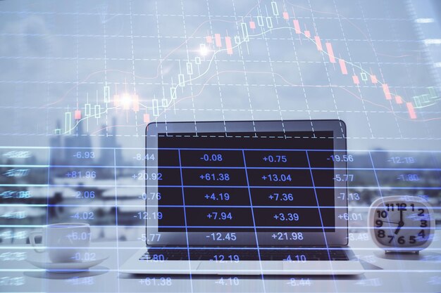 Grafico Forex ologramma sul tavolo con sfondo del computer Esposizione multipla Concetto di mercati finanziari