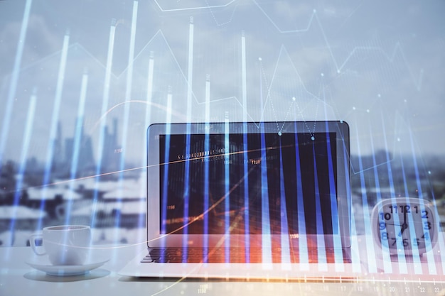 Grafico Forex ologramma sul tavolo con sfondo del computer Esposizione multipla Concetto di mercati finanziari