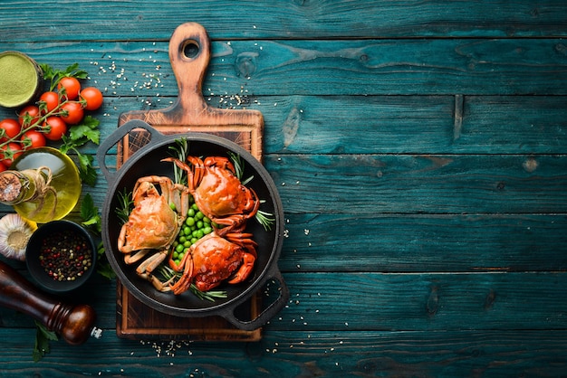 Granchi di mare bolliti con verdure in una padella nera Frutti di mare Vista dall'alto Spazio libero per il testo