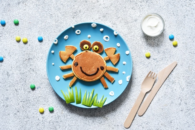 Granchio divertente su un piatto. Granchio delle frittelle, colazione per bambini.