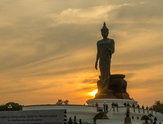 Grand Walking Buddha statua la statua principale della diocesi buddista sotto il cielo crepuscolare in Thailandia