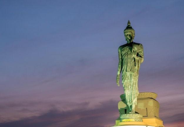 Grand Walking Buddha statua la statua principale della diocesi buddista sotto il cielo crepuscolare in Thailandia