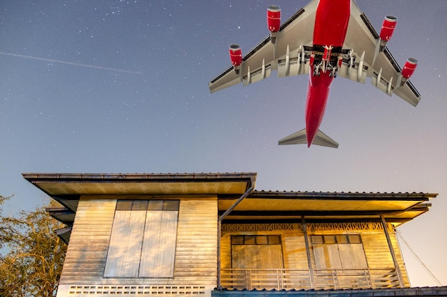 Grande aereo passeggeri sopra la casa di legno in campagna