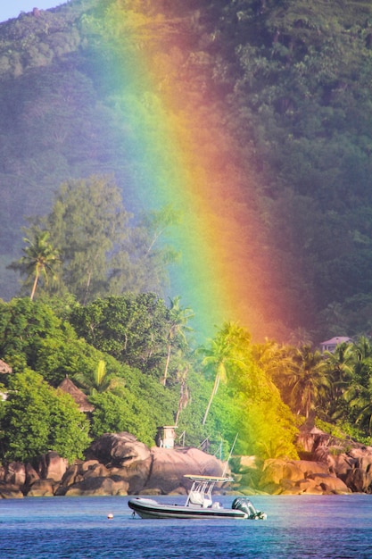 Grande arcobaleno sopra l'isola tropicale e hotel di lusso