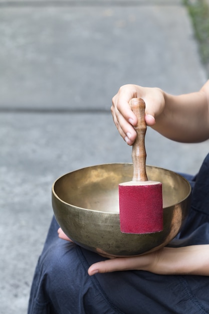 Grande ciotola di canto tibetano nelle mani di una donna