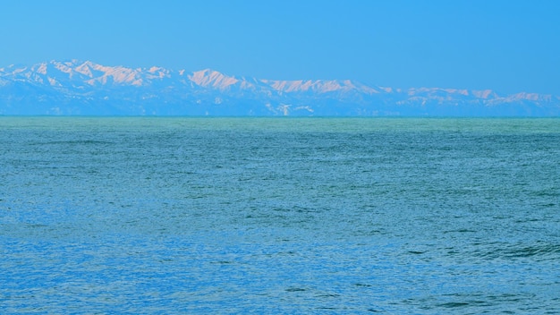 Grande corpo d'acqua con le montagne sullo sfondo le più belle spiagge del mondo in tempo reale