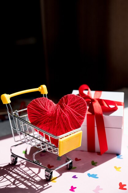 Grande cuore rosso in un carrello della spesa. Concetto per l'acquisto di amore. Shopping in linea di San Valentino. carrello con cuori.