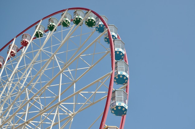 Grande e moderna rotella di ferris multicolore sul fondo pulito del cielo blu