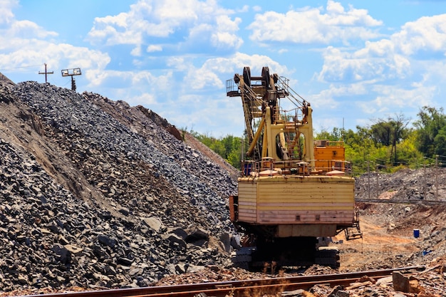 Grande escavatore che lavora nella cava di minerale di ferro Industria mineraria