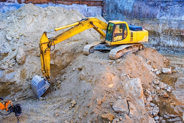 Grande escavatore giallo che lavora in cantiere