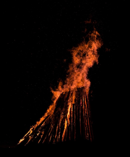 Grande falò contro il cielo notturno. Fiamme di fuoco su sfondo nero