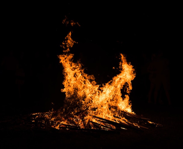 Grande falò contro il cielo notturno. Fiamme di fuoco su sfondo nero