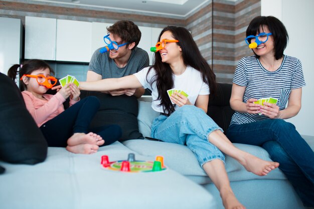 Grande famiglia a casa. Tutti insieme fanno un gioco da tavolo.