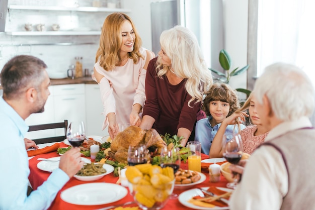 grande famiglia felice che cena insieme a casa del ringraziamento