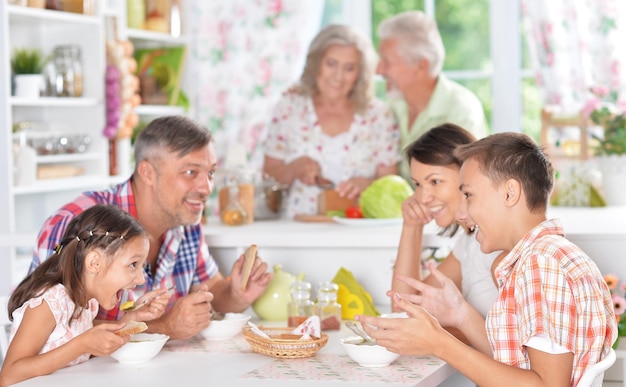 Grande famiglia felice che fa colazione insieme in cucina