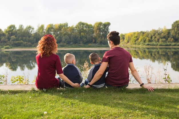 Grande famiglia seduta sull'erba