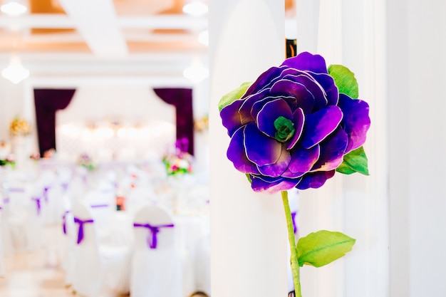 Grande fiore artificiale viola. ricevimento di nozze nel ristorante