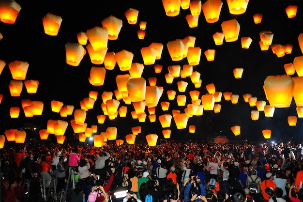 Grande folla che guarda le lanterne illuminate contro il cielo di notte