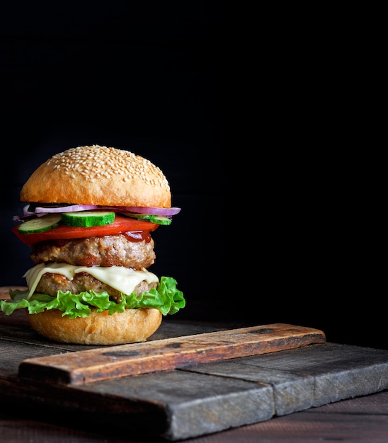 Grande hamburger con due cotolette fritte, formaggio e verdure