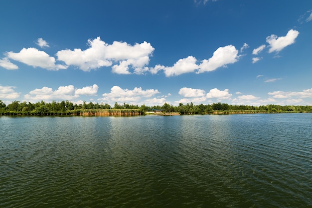 Grande lago pulito e nuvole bianche nel cielo blu. Giorno soleggiato.