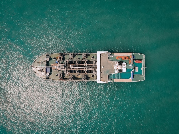 Grande petroliera che naviga mare blu verso il deposito costiero, vista dall'alto; concetto di carburante.