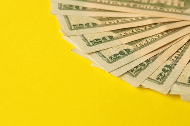 Grande quantità di vecchie venti dollari su sfondo giallo Giorno di paga dei guadagni in denaro o periodo di pagamento delle tasse