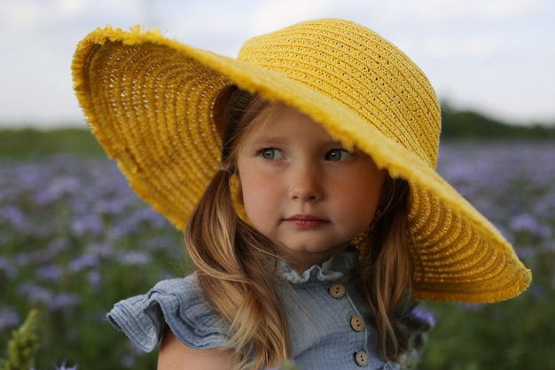 grande ritratto di una bella ragazza bionda con un cappello giallo