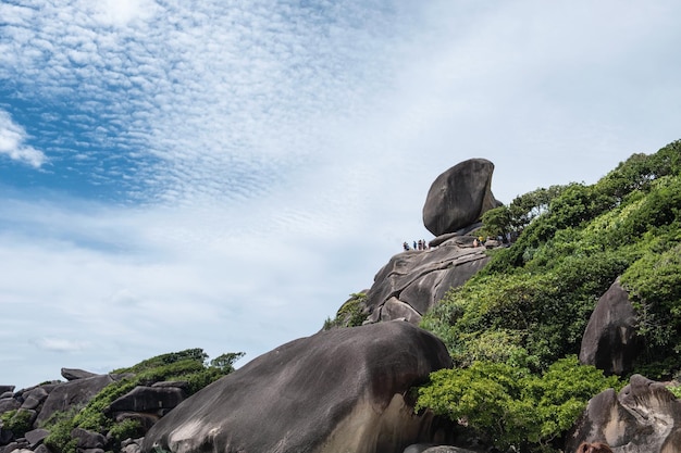 Grande roccia naturale sulla cima delle isole Similan con turisti che viaggiano in una giornata di sole