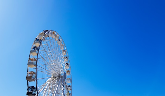 Grande ruota panoramica bianca contro il cielo blu. Parte dell'attrazione su sfondo blu con copia spazio. Cabine, piattaforme di osservazione.