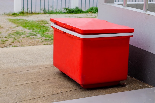 Grande secchio di ghiaccio rosso o refrigeratore sul pavimento.