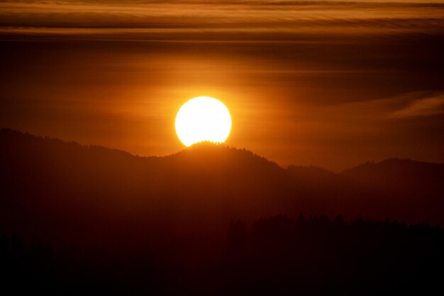 Grande sole e silhouette di montagne