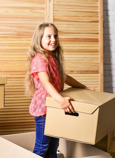 Grande spazio di archiviazione. Pacchetto scatola e stoccaggio. Bambino piccolo prepararsi per il trasferimento. Trasferirsi in famiglia stressante per i bambini. Ragazza del bambino che trasferisce lo sfondo delle scatole. Concetto di trasferimento. Servizio di consegna.