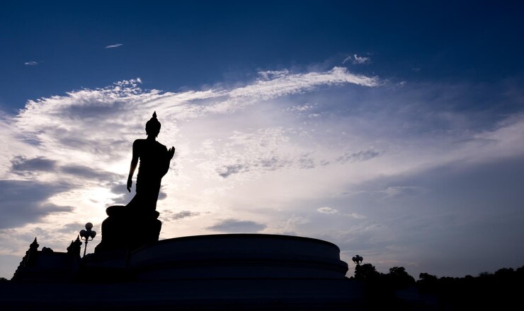 Grande statua in bronzo di buddha a piedi nella provincia buddista di Phutthamonthon Thailandia nel cielo crepuscolare