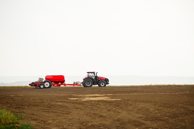 Grande trattore moderno per la preparazione del campo dopo l'inverno per la semina del grano