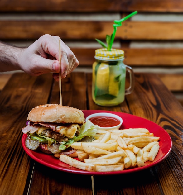 Grandi cheeseburger e patatine fritte su un piatto.