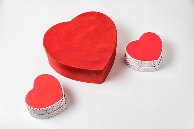 Grandi e due piccole scatole a forma di cuore rosso sul tavolo. Sopra la vista. San Valentino