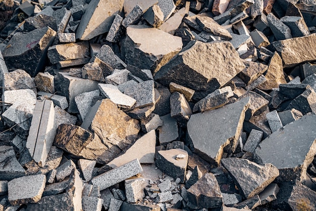 Grandi e piccoli pezzi di pietre che ricoprono il terreno Massi con lati piatti che giacciono nel mucchio Pietre di granito si chiudono