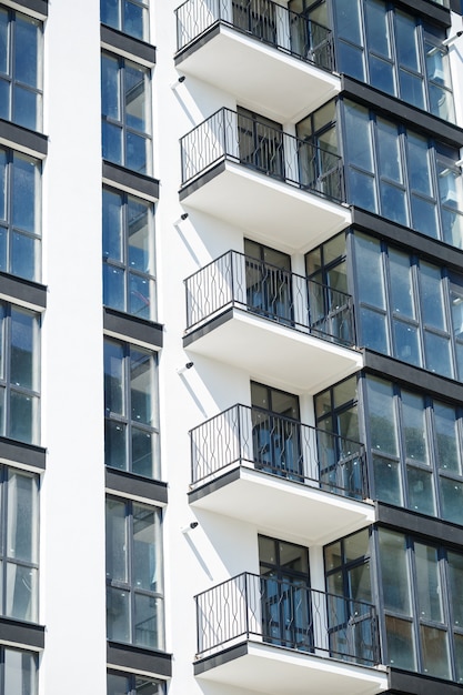 Grandi finestre panoramiche in plastica. Facciata di un nuovo edificio in casa durante i lavori di costruzione. Edificio a più piani durante la costruzione