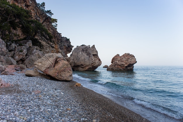 Grandi massi vicino alla scogliera in riva al mare