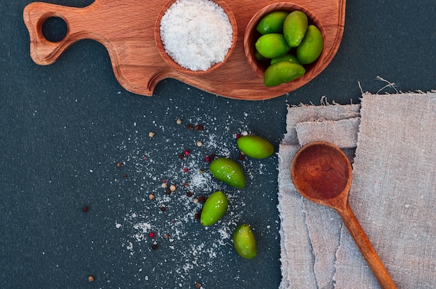 Grandi olive verdi e sale, cucchiaio di legno