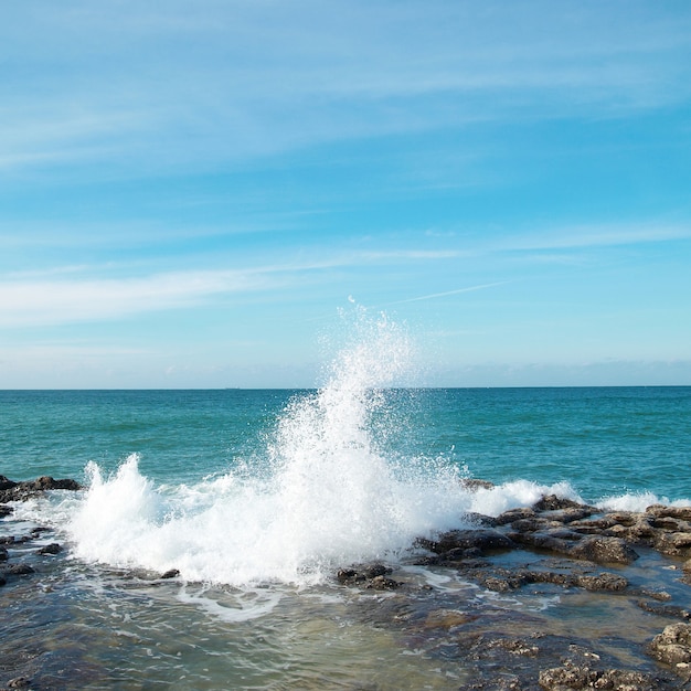 Grandi onde che si infrangono sulla riva con schiuma di mare