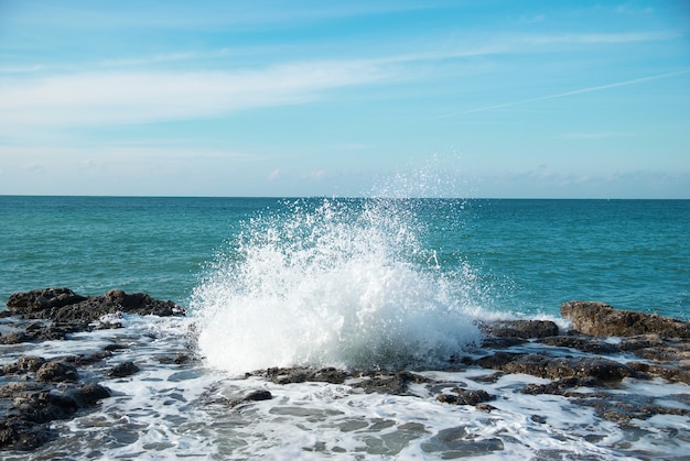 Grandi onde che si infrangono sulla riva con schiuma di mare